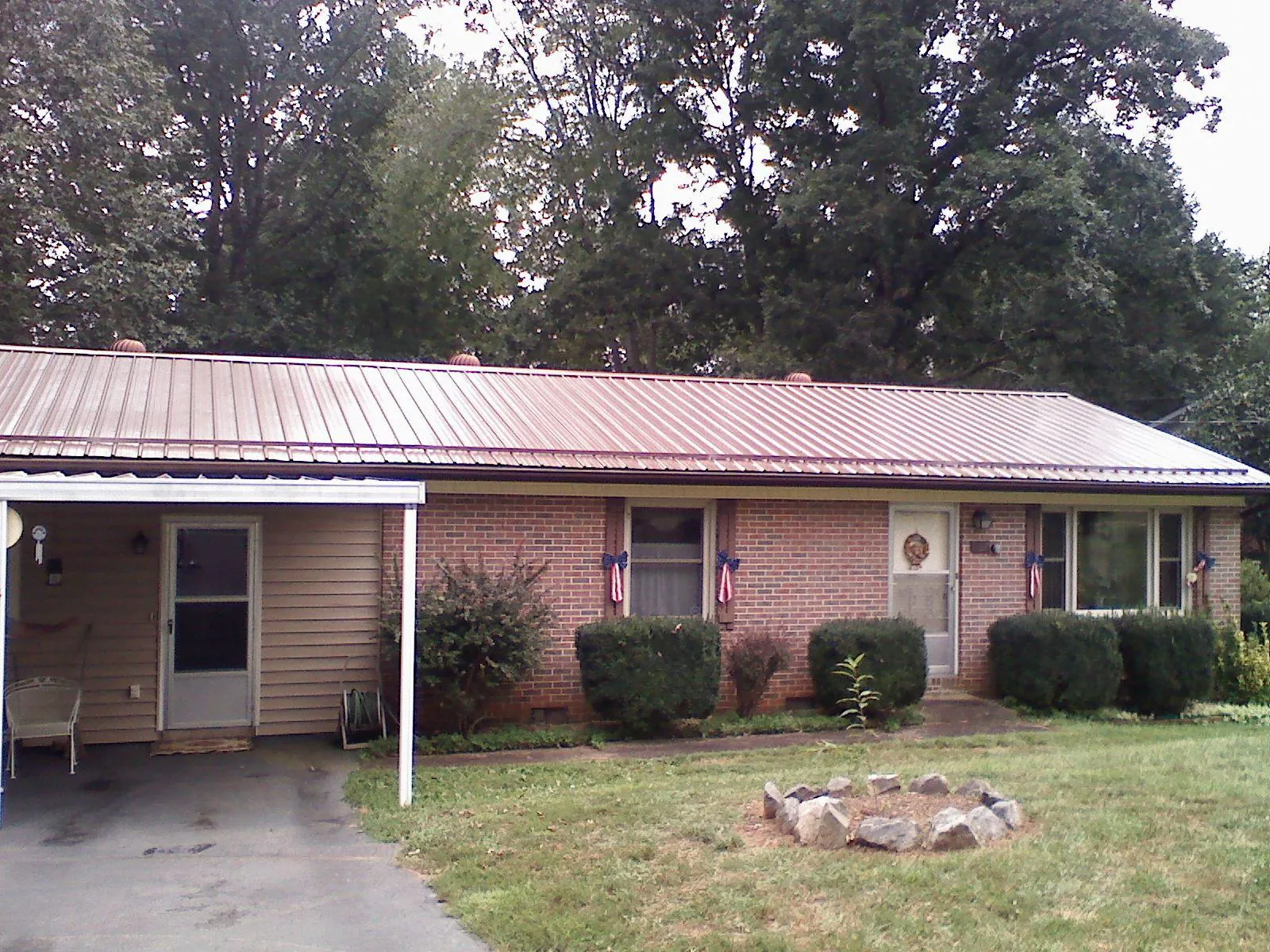 Bronze metal roof and carport on a brick ranch home — Roof Repair work by our crew in Lathrop
